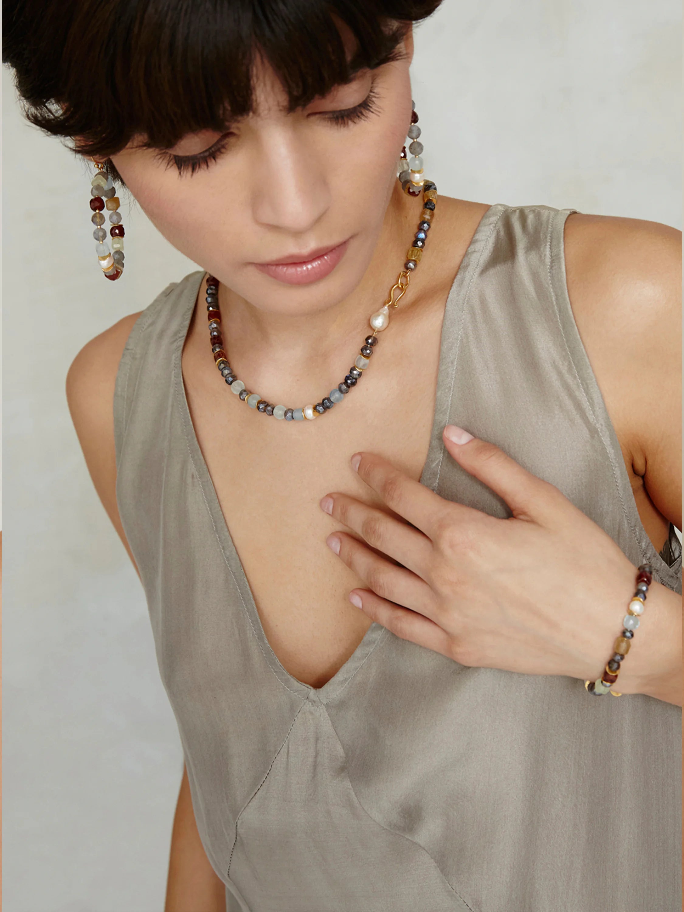Multi-stone necklace and bracelet with grey, brown, and burgundy beads; gold accents; and a single pearl.