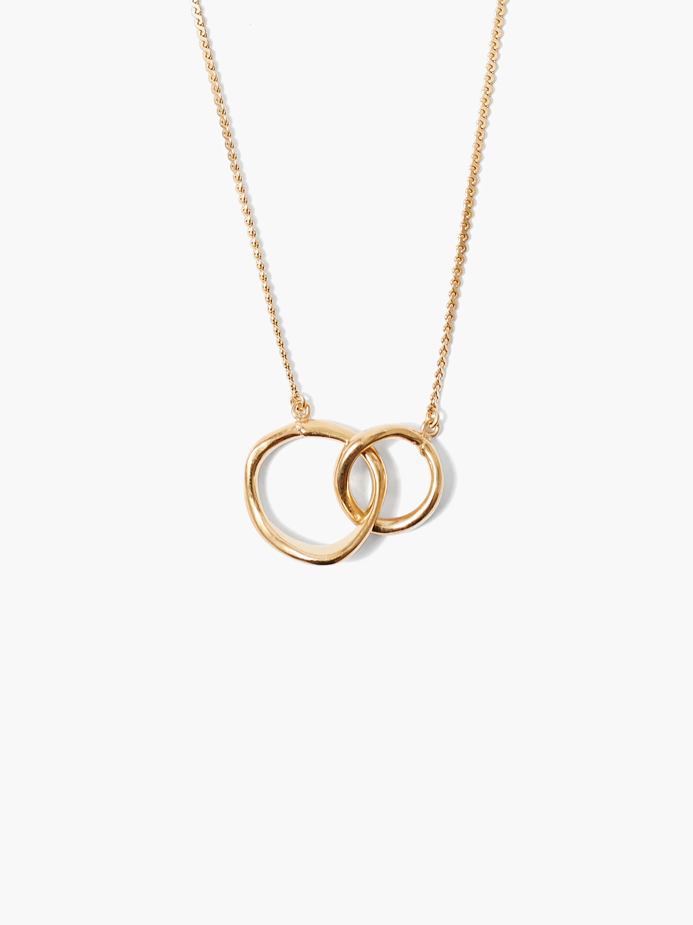 Gold necklace with two interlocking, fluid-shaped loops on a delicate chain.