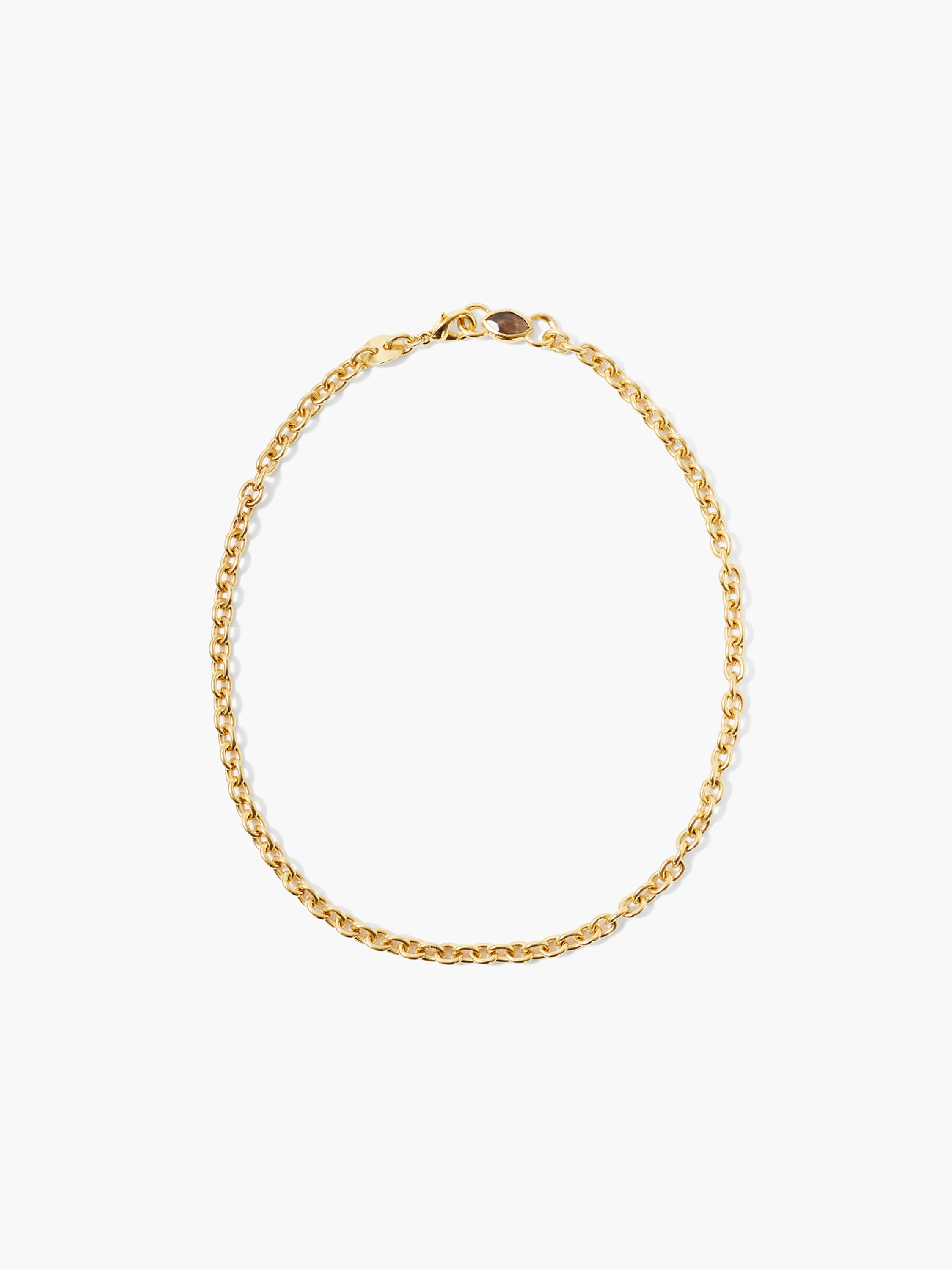 Gold oval-link chain necklace with a small smokey quartz stone near the clasp.