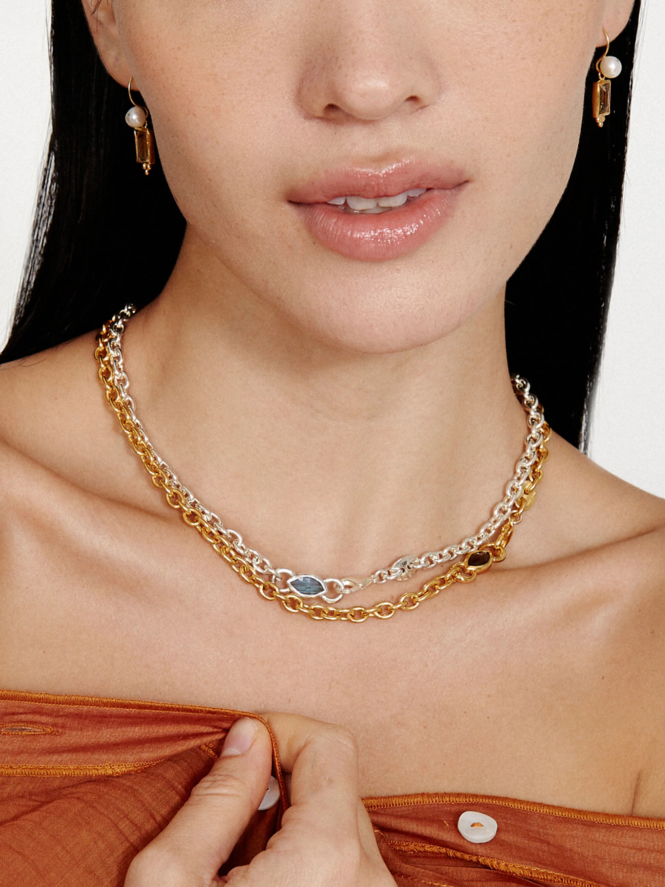 Layered necklace with gold & silver chains, a dark rectangular smokey quartz, & a light blue marquise stone.