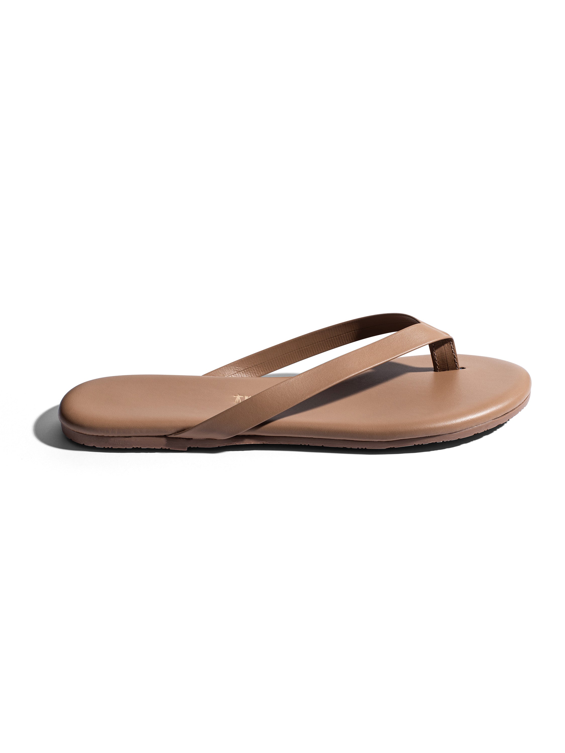 Minimalist flat nude leather thong sandals feature thin straps and a smooth footbed.