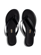 Pair of black thong-style flip-flops with gold 'TKEES' logo on the insole.
