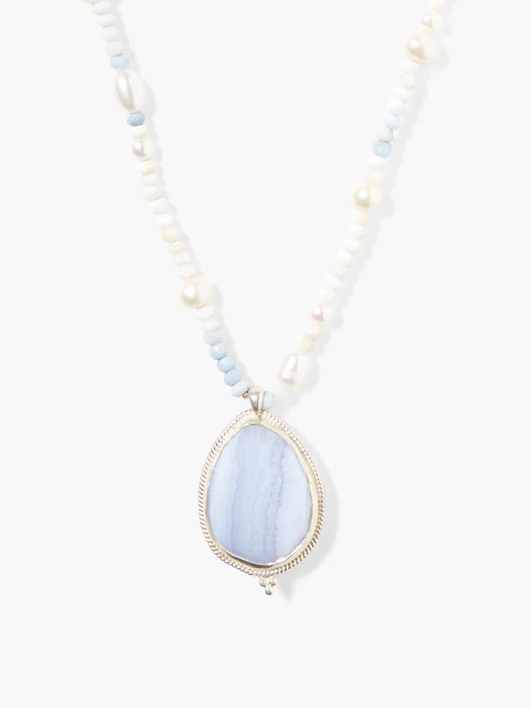 Teardrop blue lace agate pendant with silver frame. Beaded necklace includes white pearls and light blue beads.