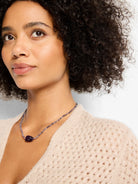 Small, faceted violet beads form a choker, with a larger, dark purple irregular center stone.