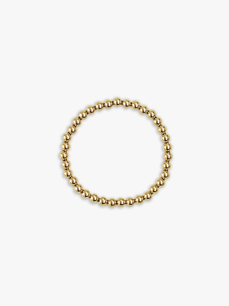 Bracelet of small, shiny gold beads, forming a circle.