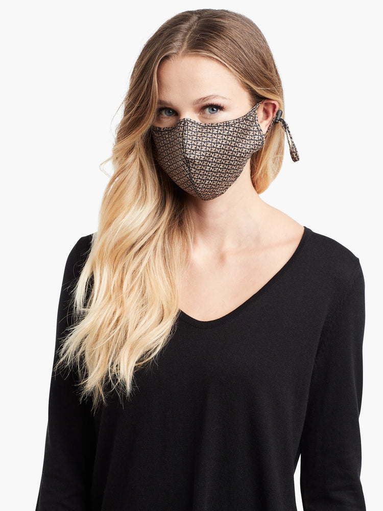 Beige and black patterned face mask with black ties.