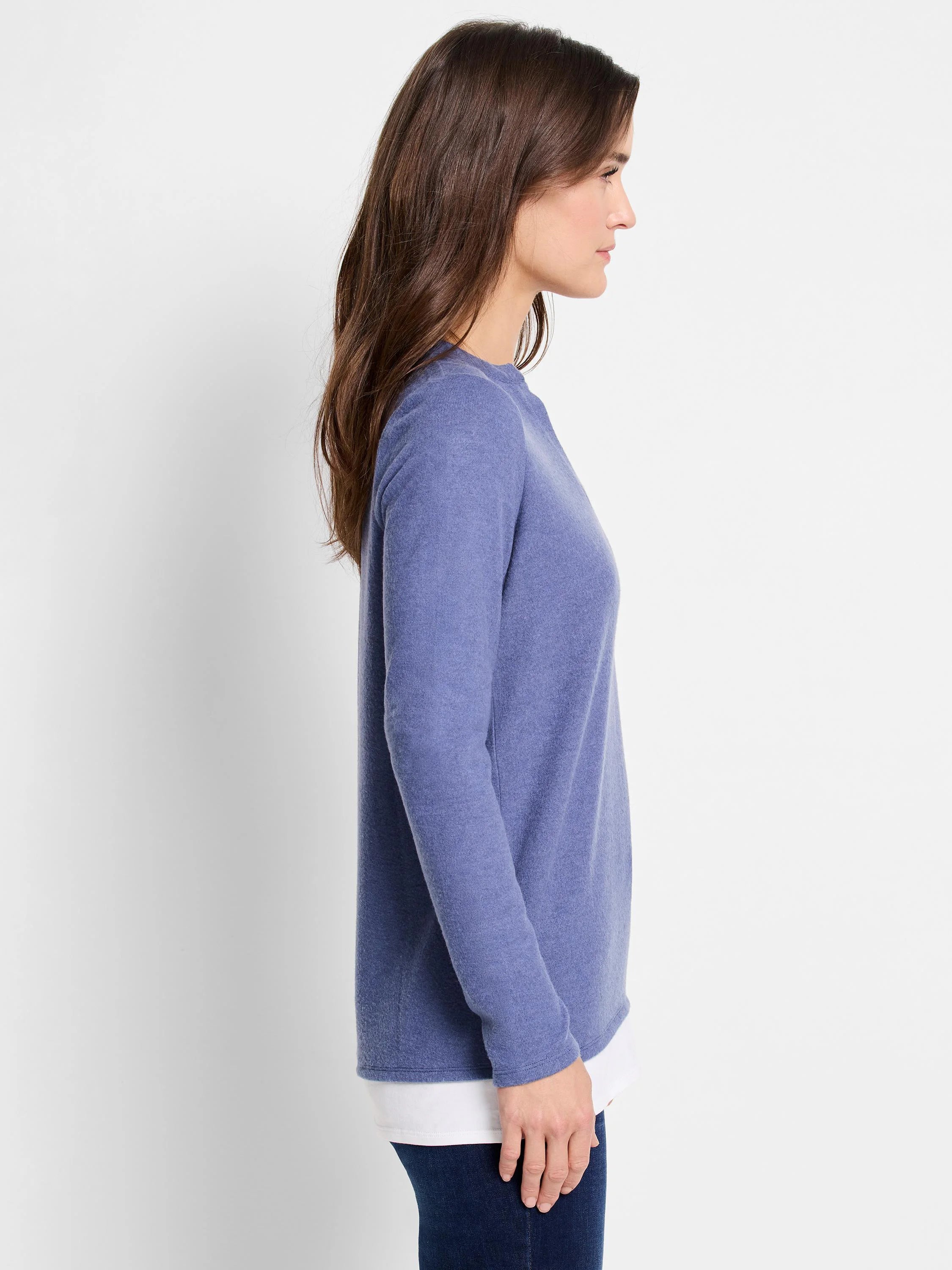 Side profile of a periwinkle blue, long-sleeve layered top. The top layer is a slightly textured knit, and a white...