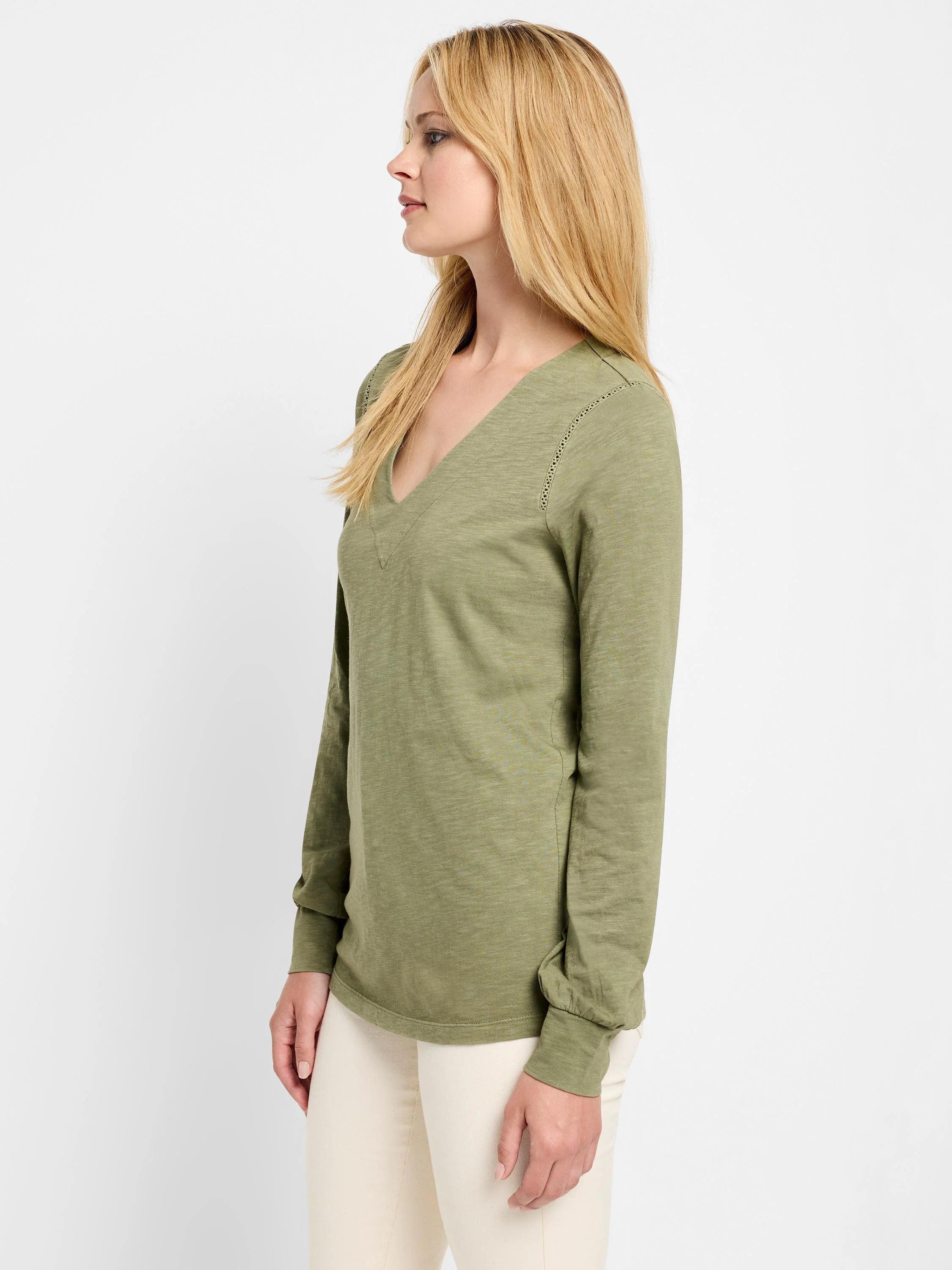 Olive green long-sleeve V-neck top. Lace detail at neckline and shoulders.