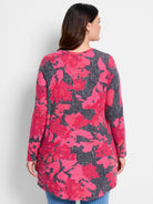 Long-sleeve shirttail tee with pink and gray floral print on a charcoal gray background.  Long, relaxed fit.