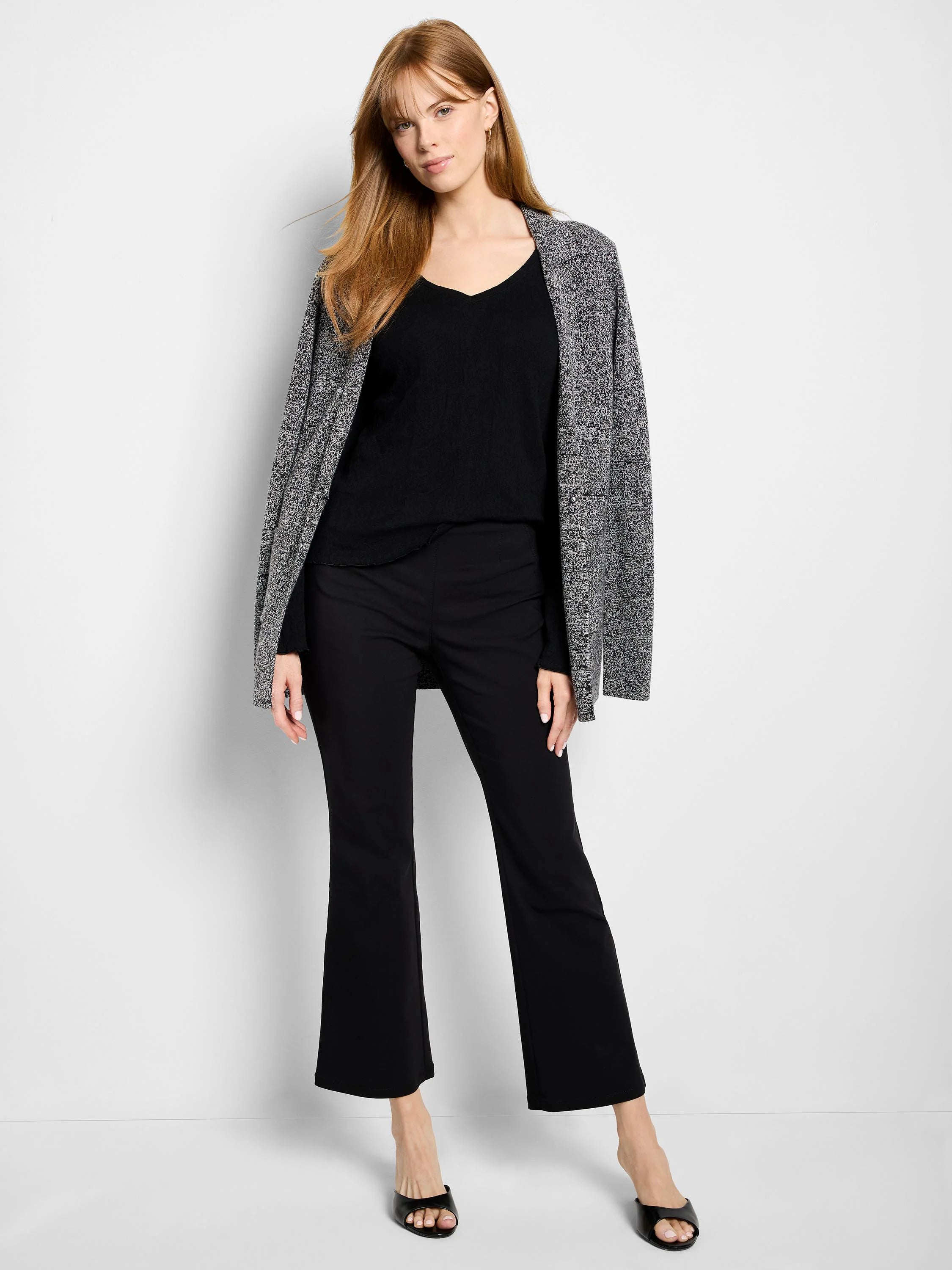 Black V-neck knit shirt. Image shows model wearing it under a gray and white cardigan.