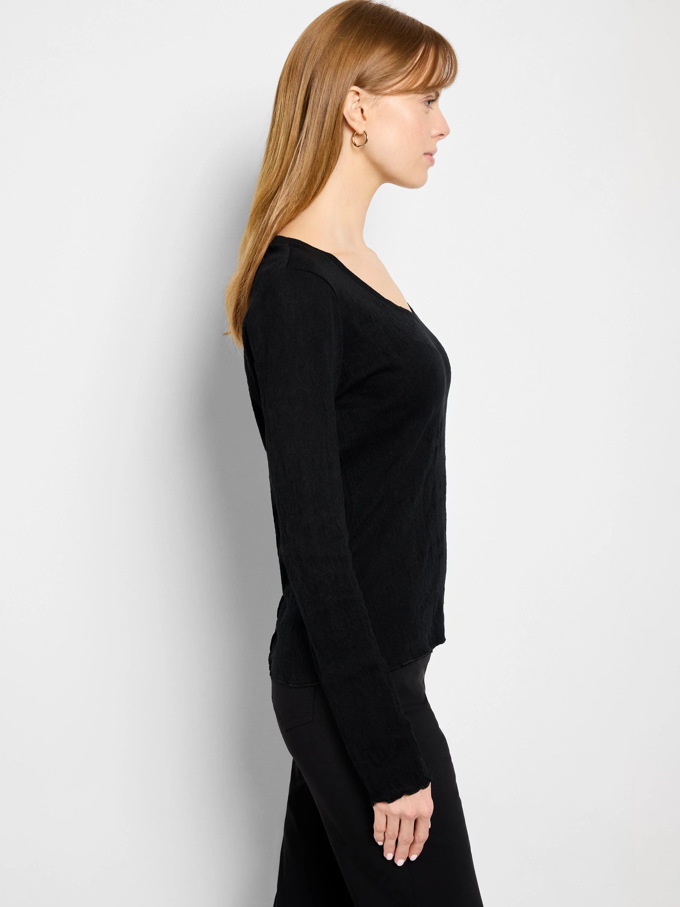 Black, long-sleeved V-neck knit top. Slightly textured fabric. Relaxed fit.