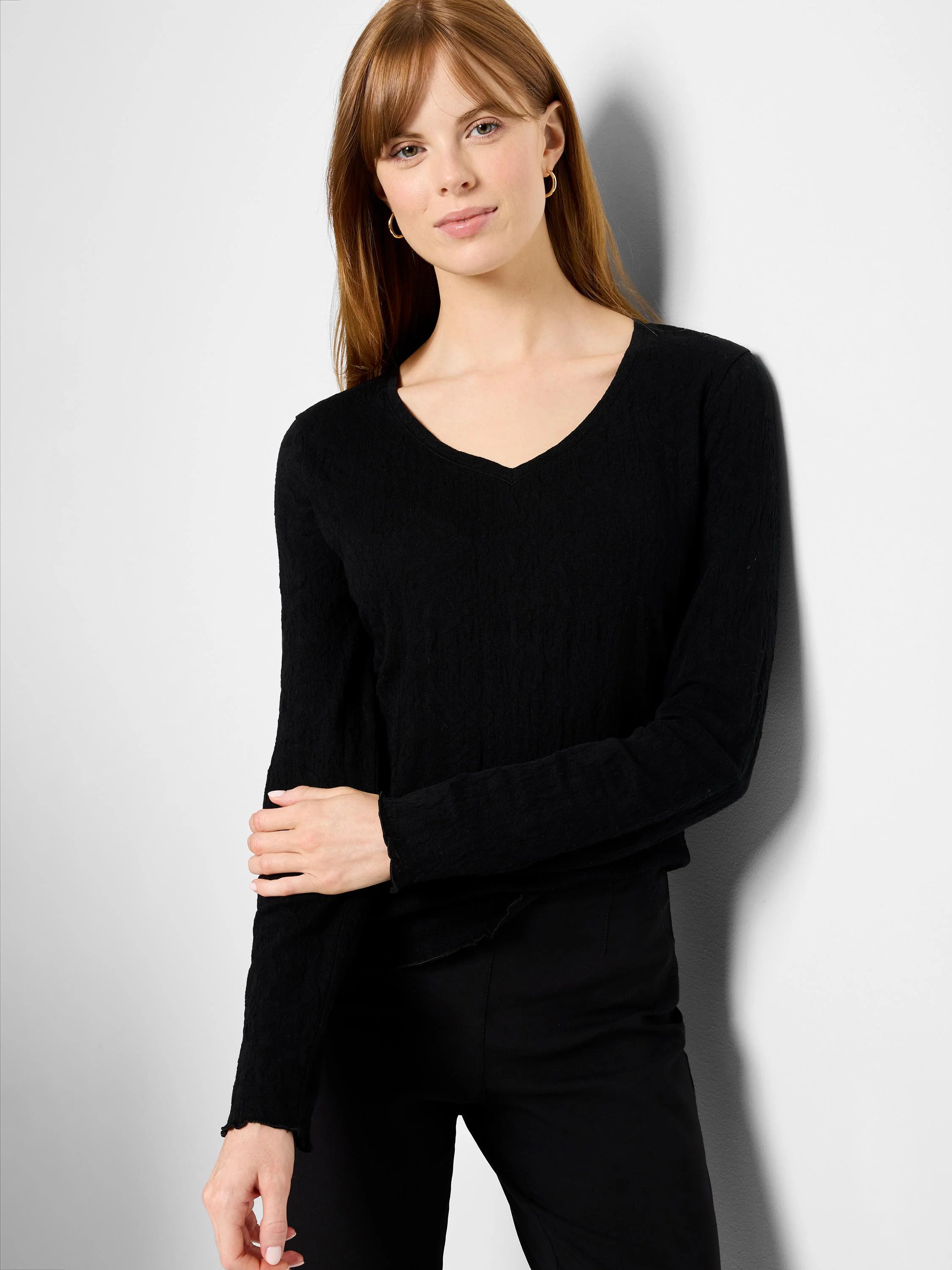 Black, long-sleeved V-neck knit shirt. Textured fabric.