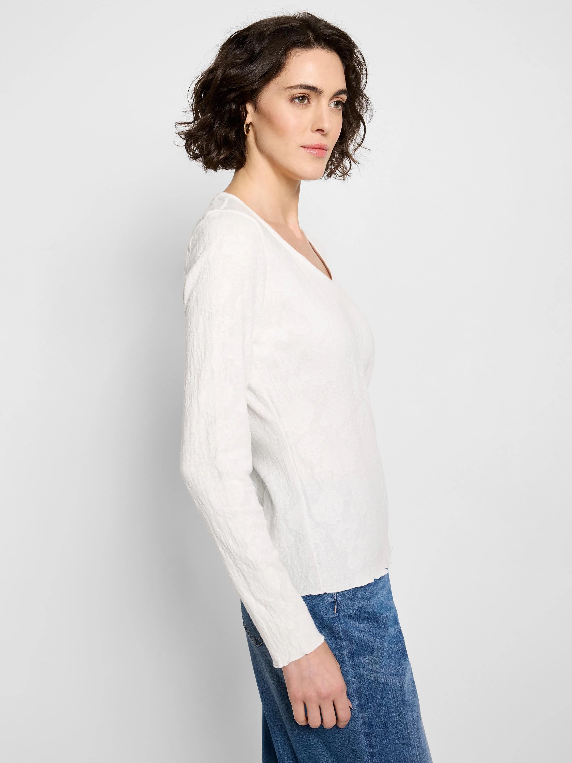 Off-white, long-sleeve V-neck knit shirt with textured fabric.