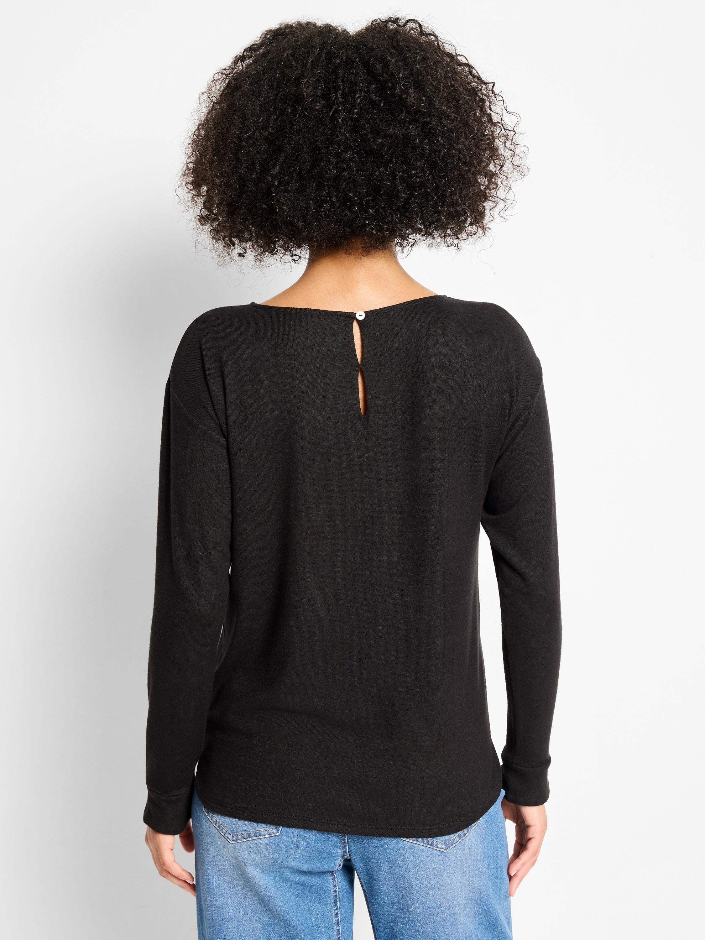 Black long-sleeved top, relaxed fit. Features a wide back neckline with a keyhole opening secured by a white button.