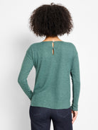 Back view of a person in a heathered teal long-sleeve top with a keyhole button closure at the nape.