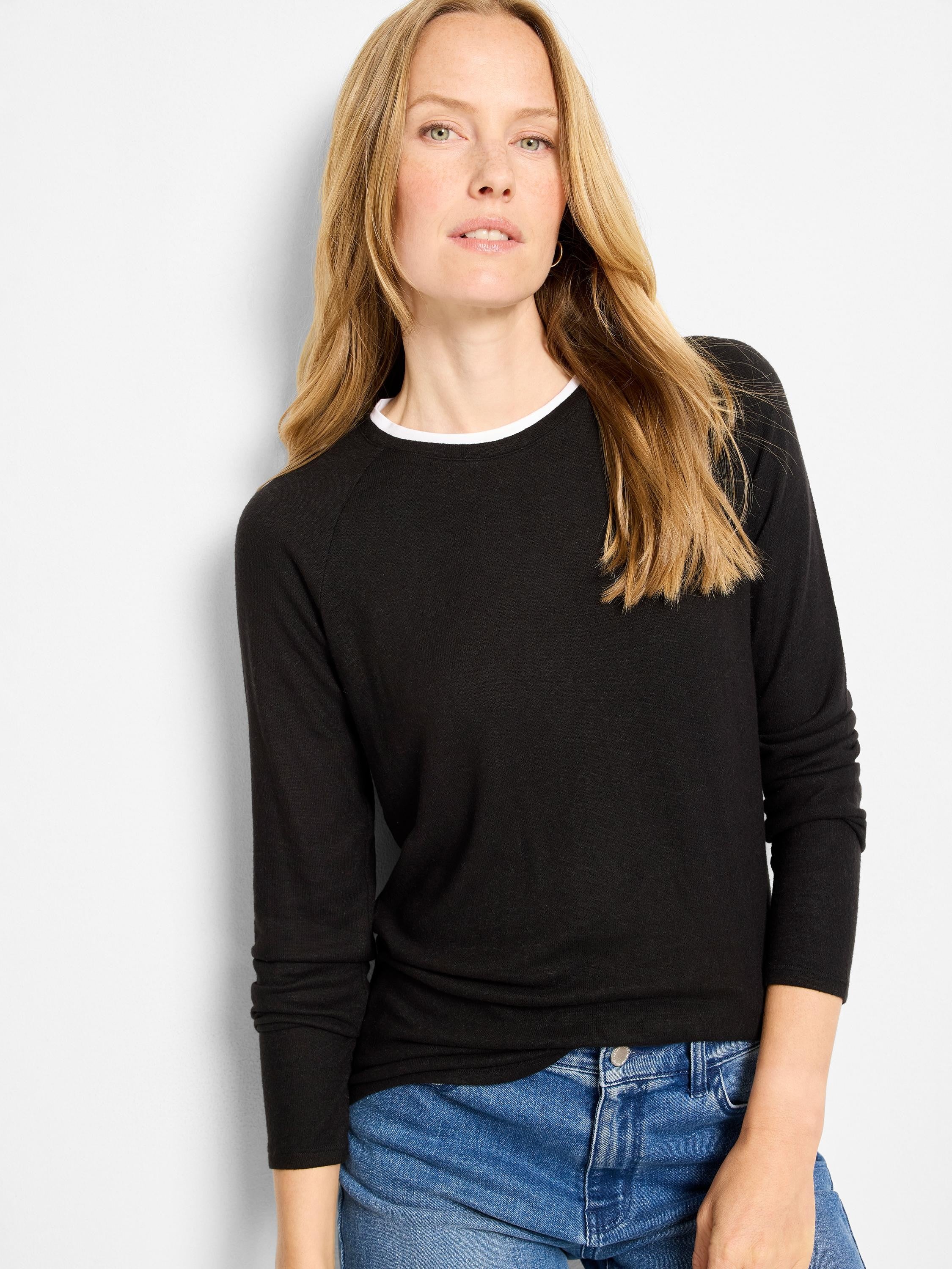 Black long-sleeved top with a white inner layer showing at the crewneck.