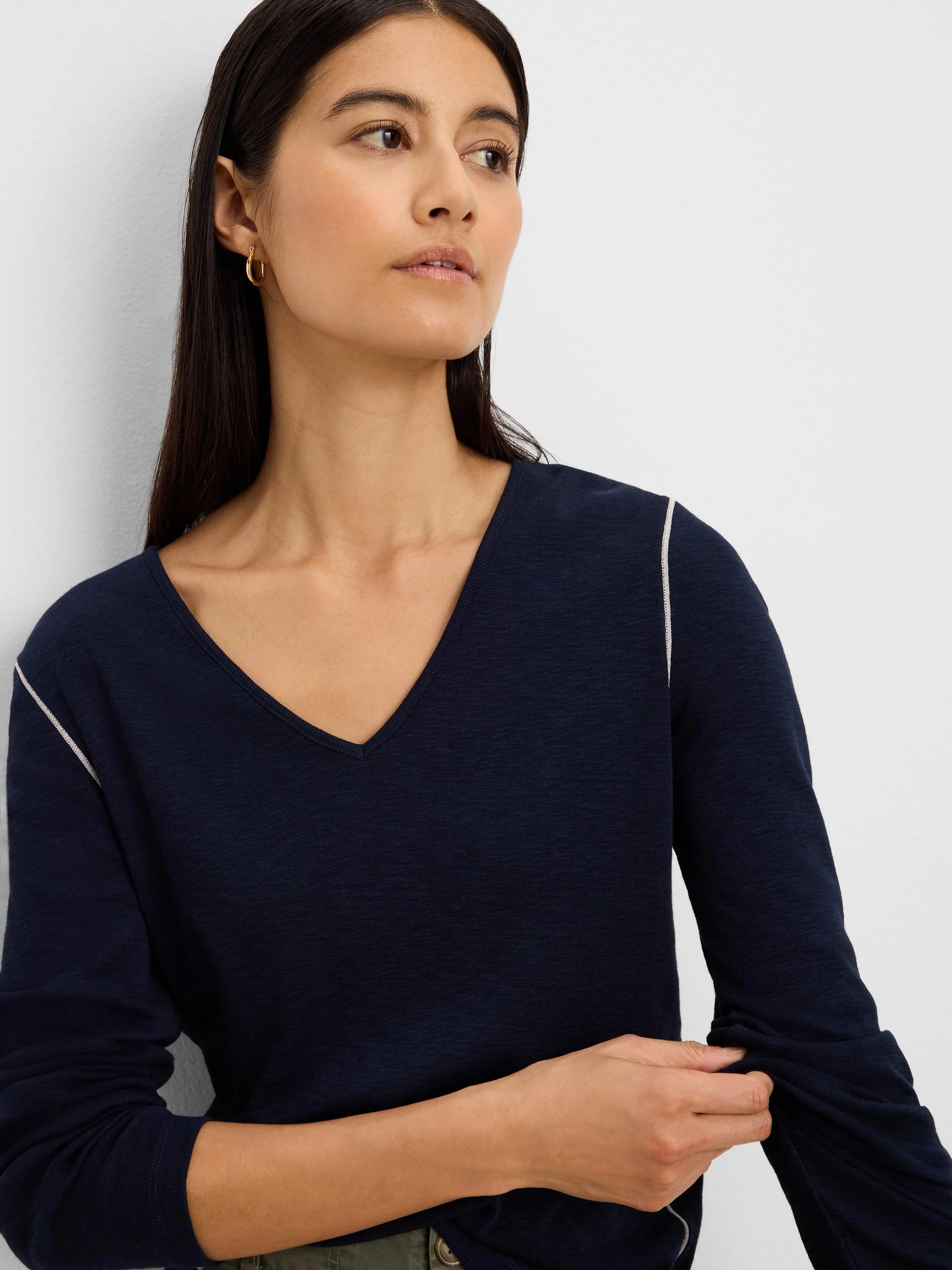 Navy long sleeve V-neck tee with white contrast stitching on shoulders, shown worn.
