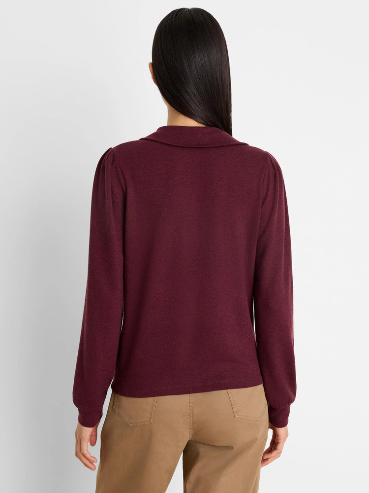 Burgundy knit puff sleeve tee with a collar, seen from behind on a model wearing brown pants.