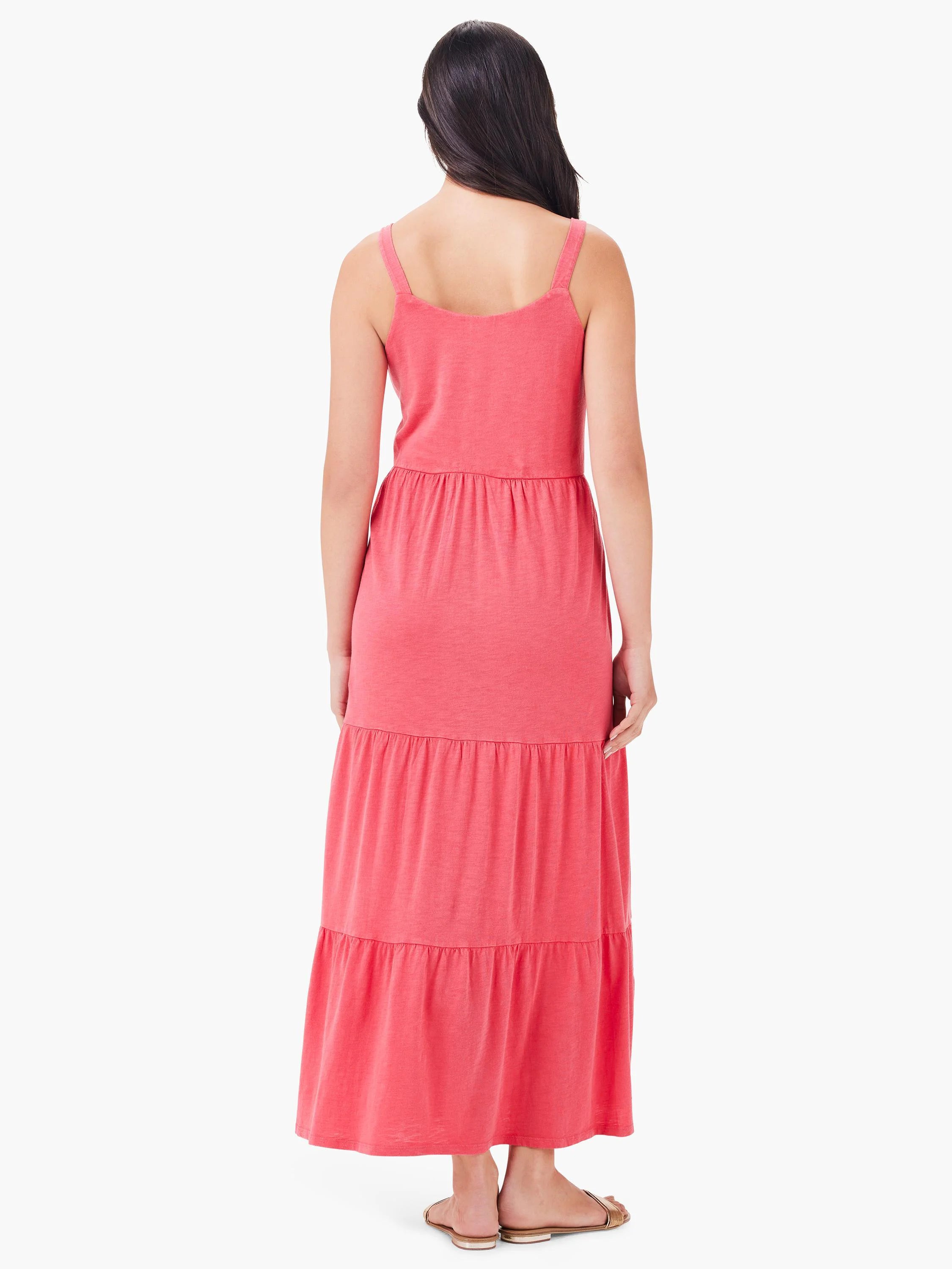 Coral pink tiered maxi dress with thin straps. Shown from the back.
