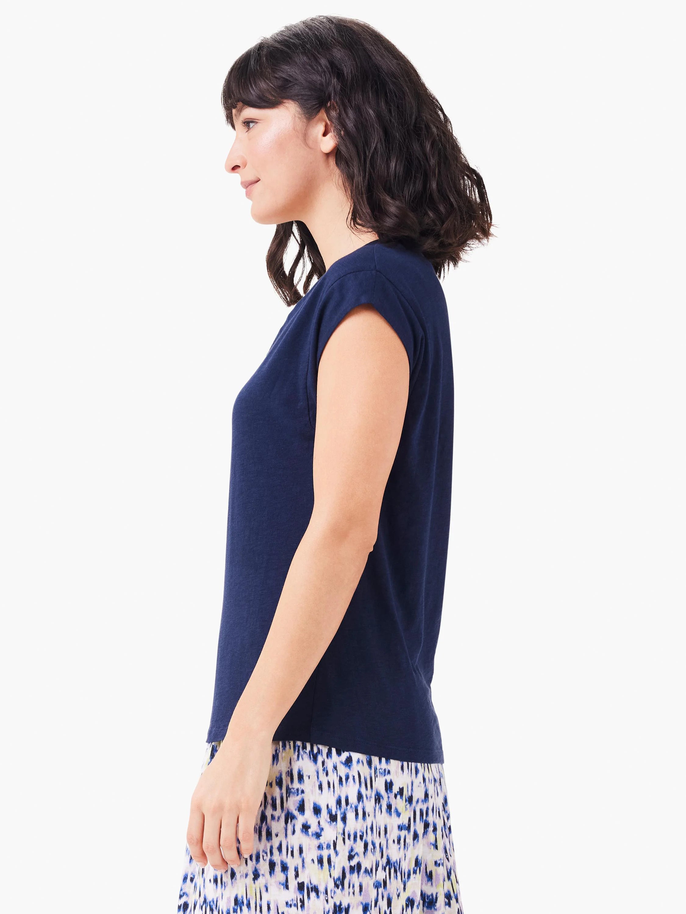 Here's alt text under 125 characters:
Navy blue v-neck tank top; short sleeves. Side profile view on model.
