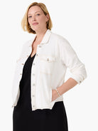 White denim-look jacket with tan contrast stitching, silver buttons, chest pockets, and a raw hem.
