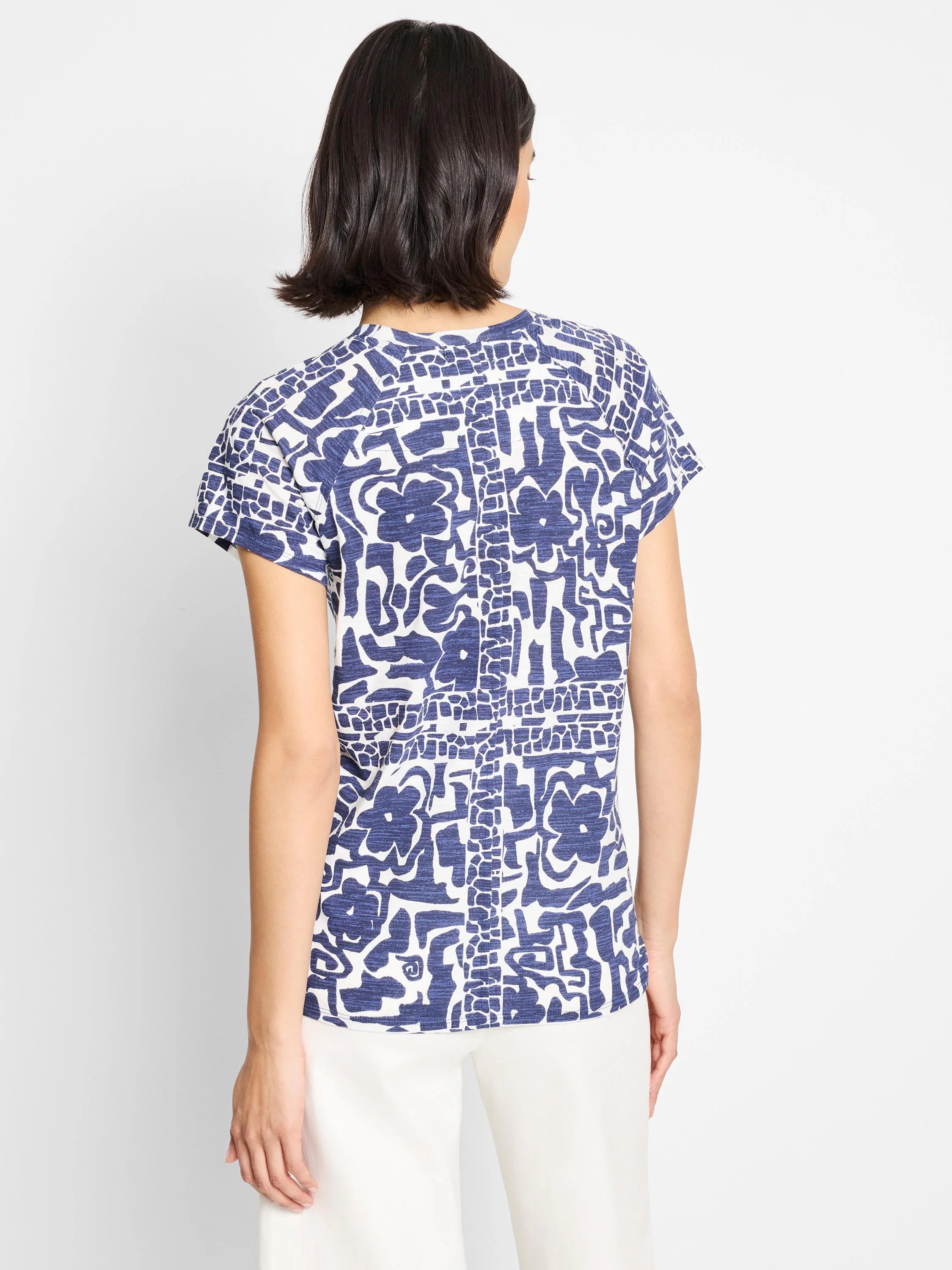 Cream crew neck tee with short sleeves, featuring a navy blue abstract floral print.