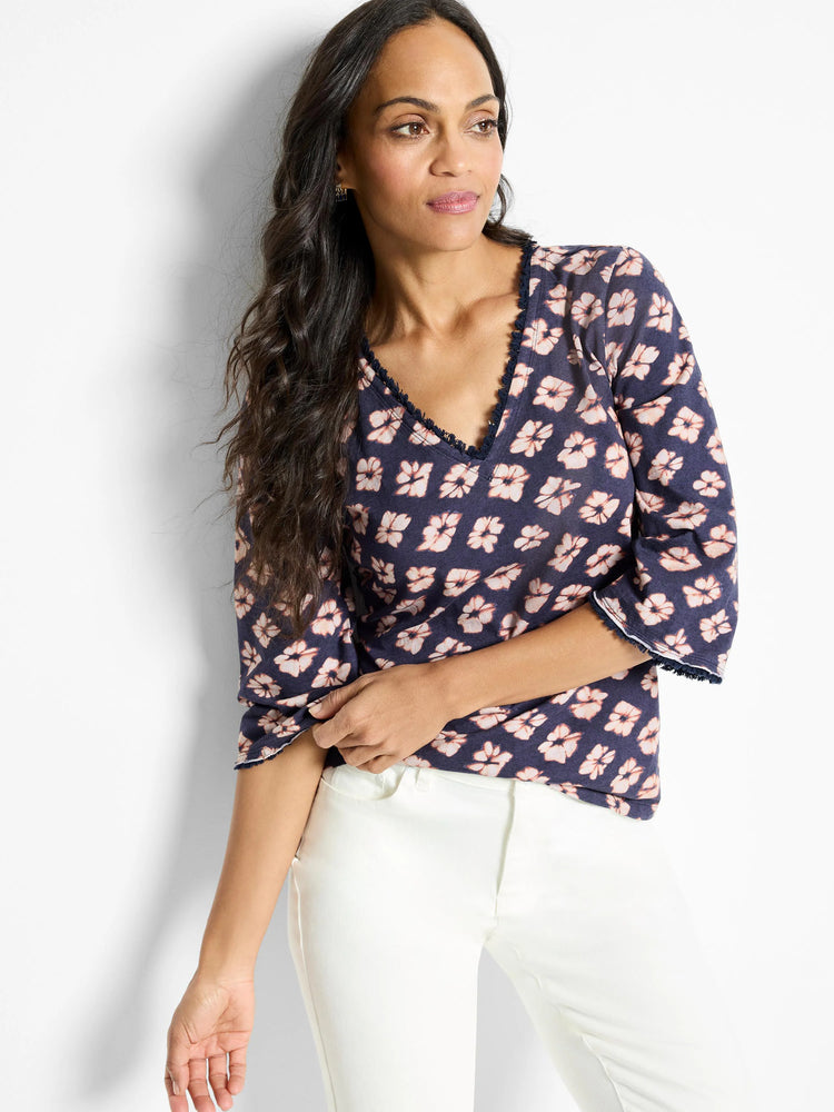 Navy blue 3/4 sleeve shirt with a pink floral pattern and a frayed neckline and sleeve hems. V-neck.