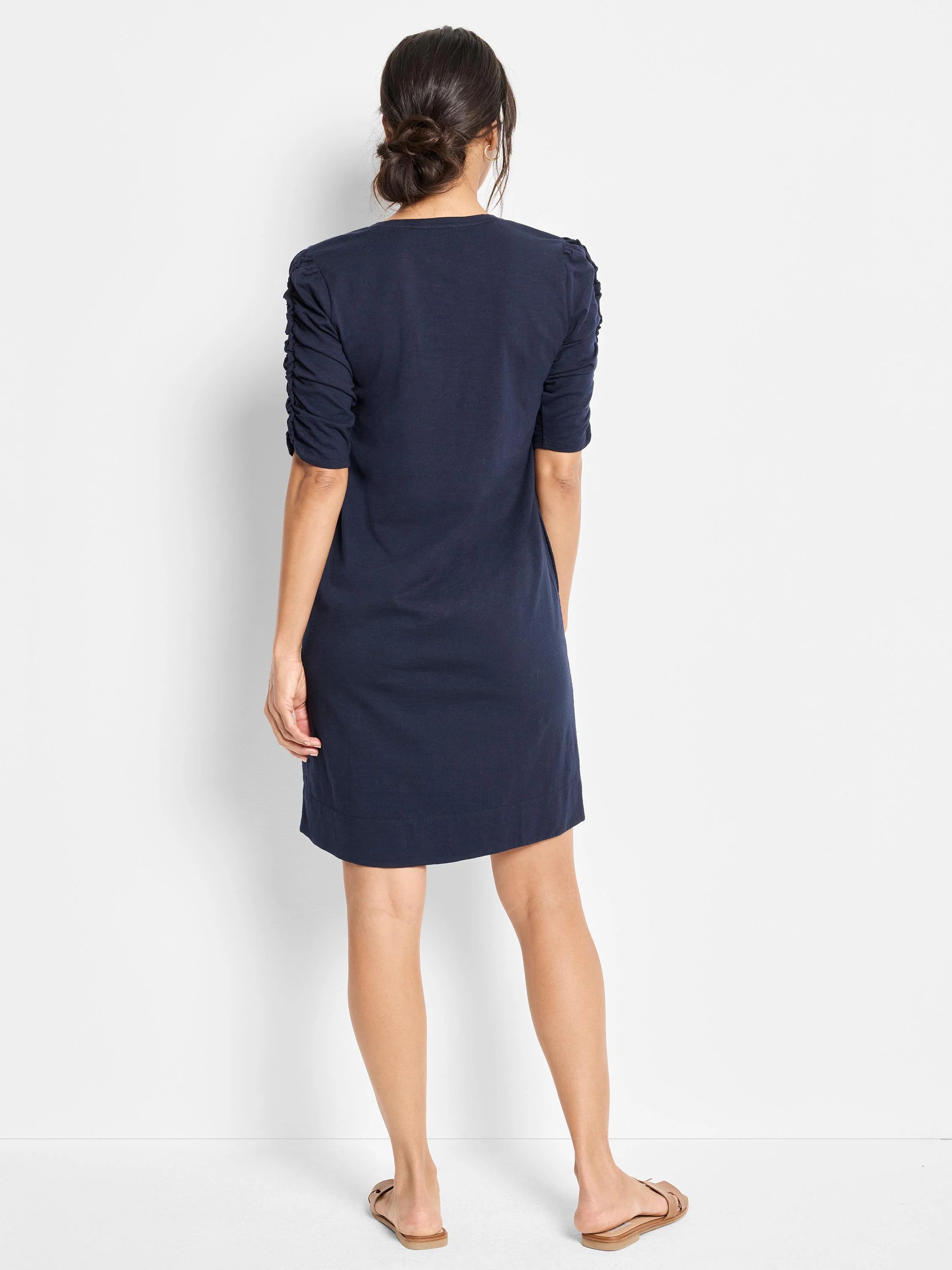 Navy blue short-sleeved dress with ruched elbow sleeves. Back view.