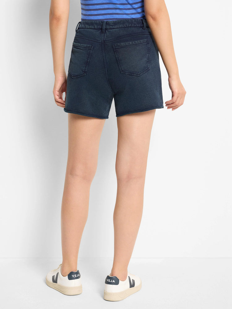 Dark wash denim shorts, back view. Features two back pockets. Raw hem.
