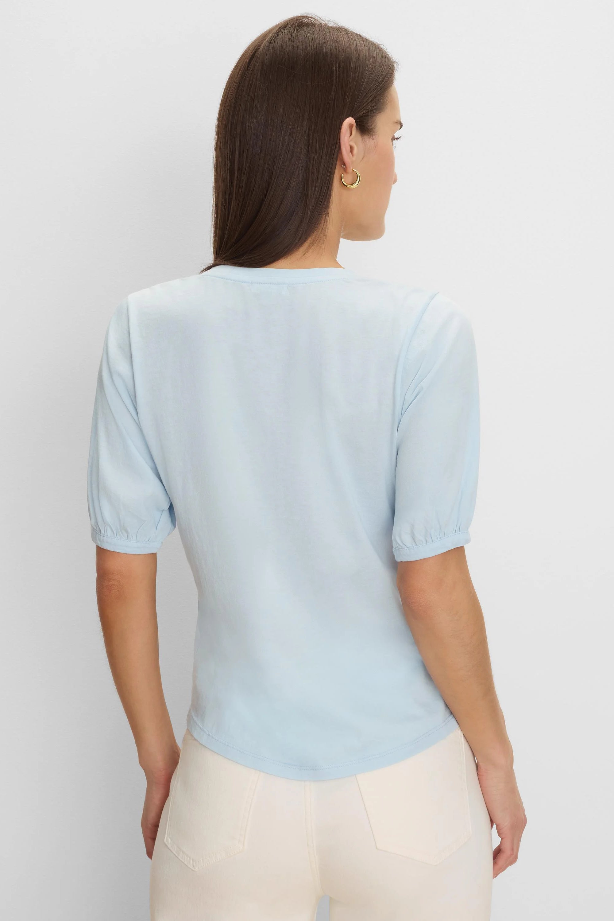 Light blue tee with elbow-length sleeves, gathered cuffs, and rounded back hem on a model.