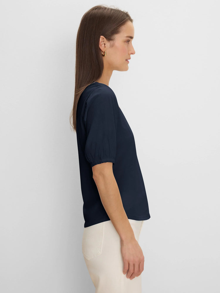 Dark blue V-neck tee with elbow sleeves and gathered cuffs, worn by model in profile.