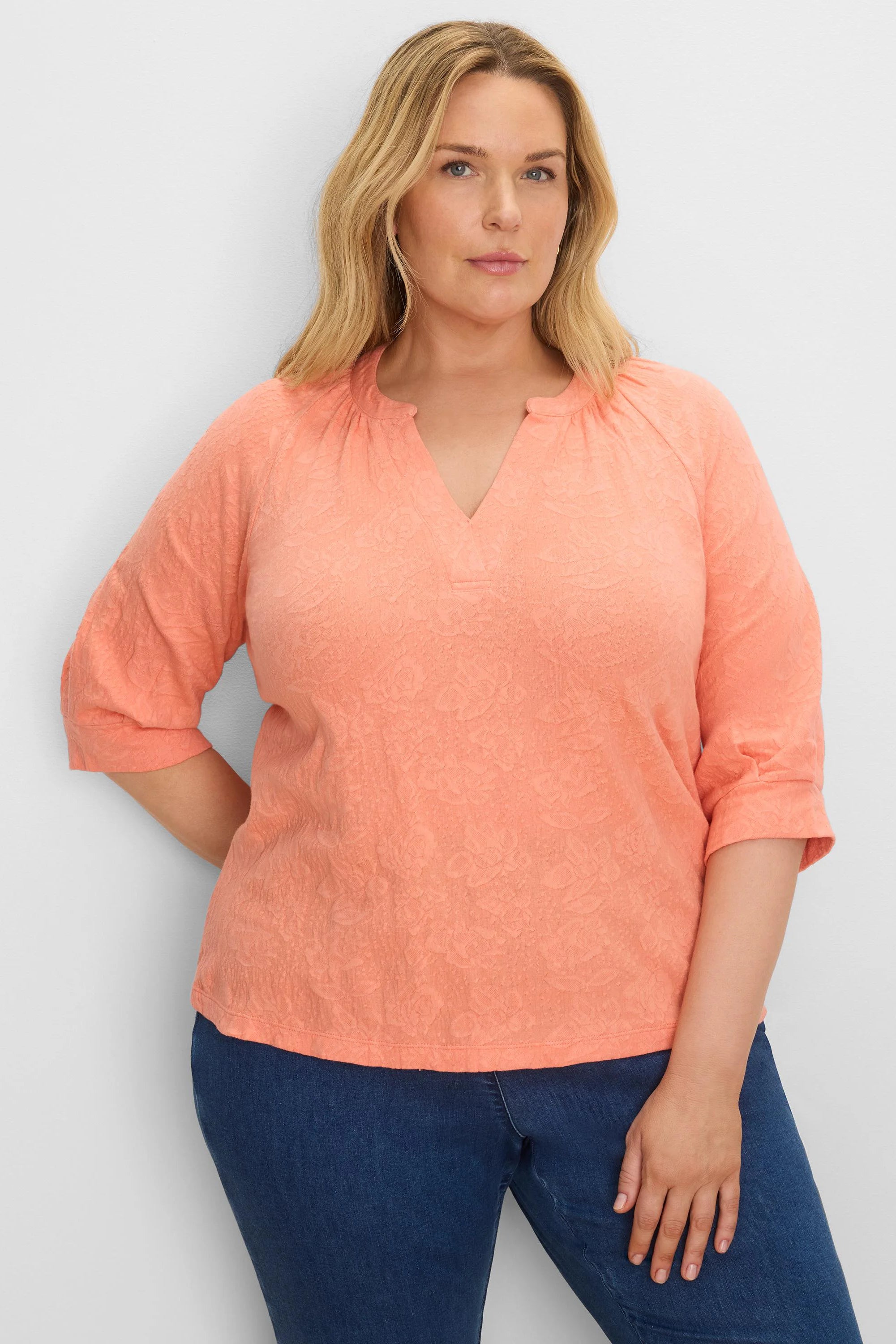 Peach floral lace knit split neck top with cuffed three-quarter sleeves.