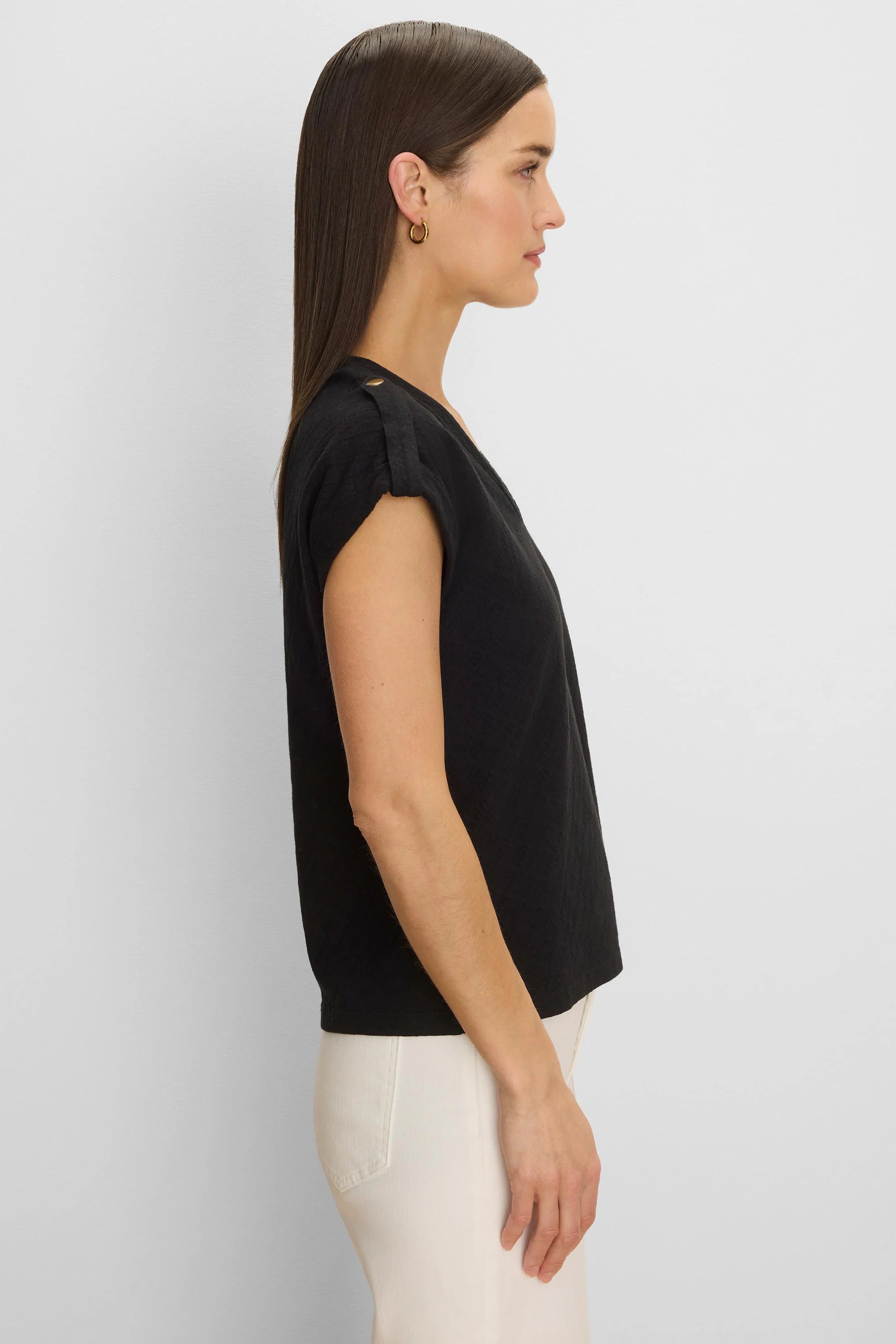 Black textured knit tee, relaxed fit. Cap sleeves with gold button shoulder tabs.