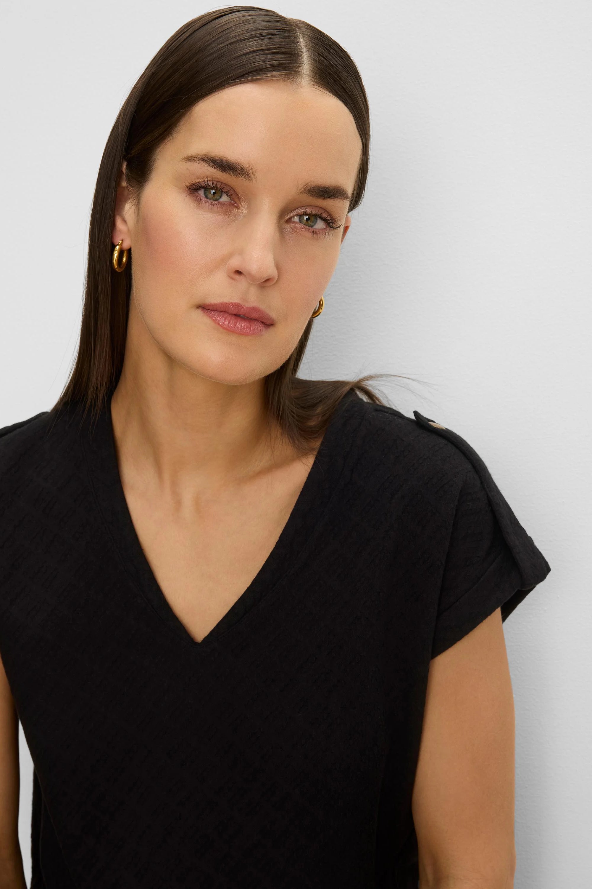 Black lace knit tee with V-neck and rolled cap sleeves.