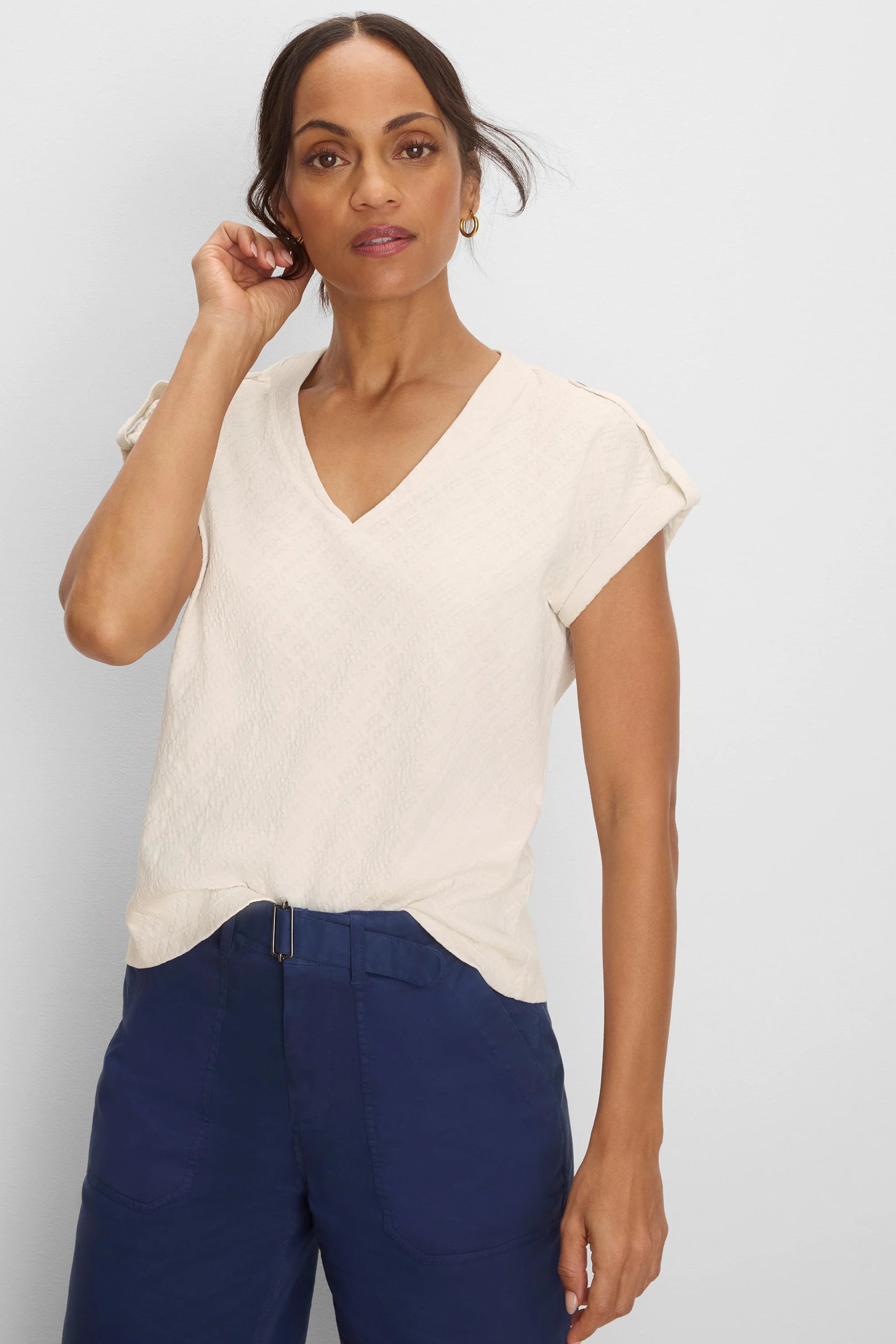 Cream V-neck tee with cap sleeves and a subtle lace knit texture.