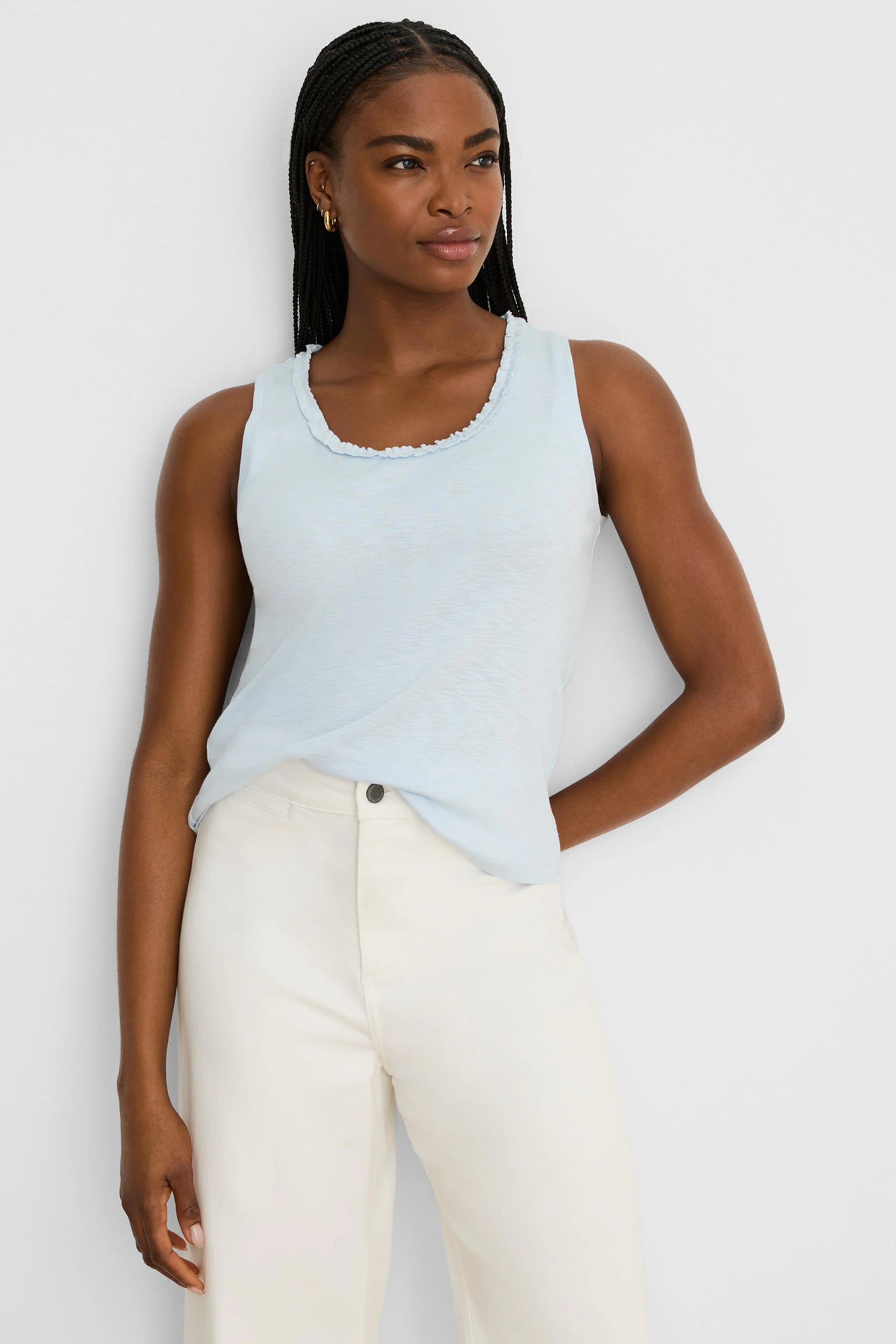 Light blue cotton slub tank with a soft ruffled scoop neck. Model wears it.