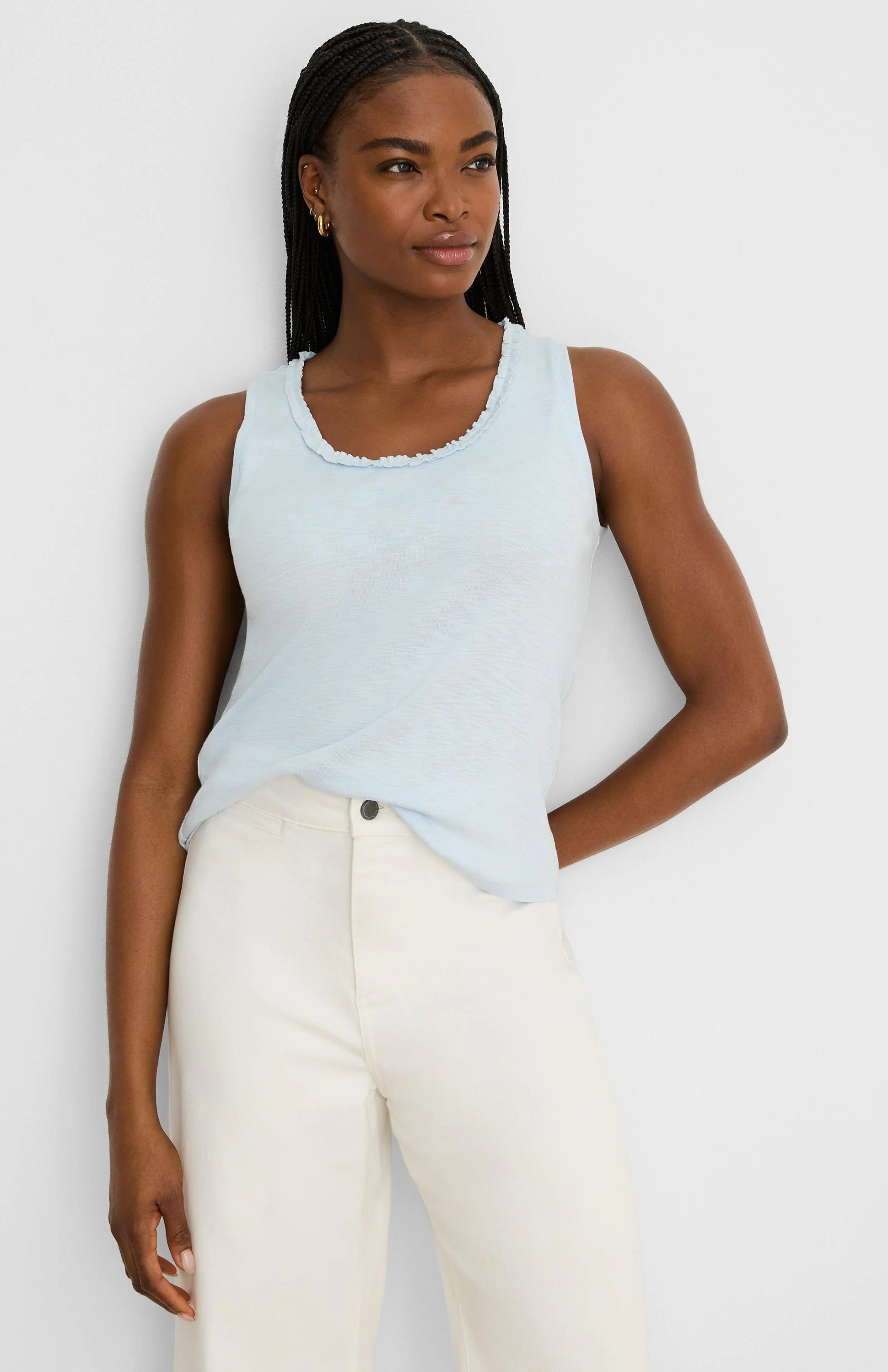 Light blue cotton slub tank with a soft ruffled scoop neck. Model wears it.