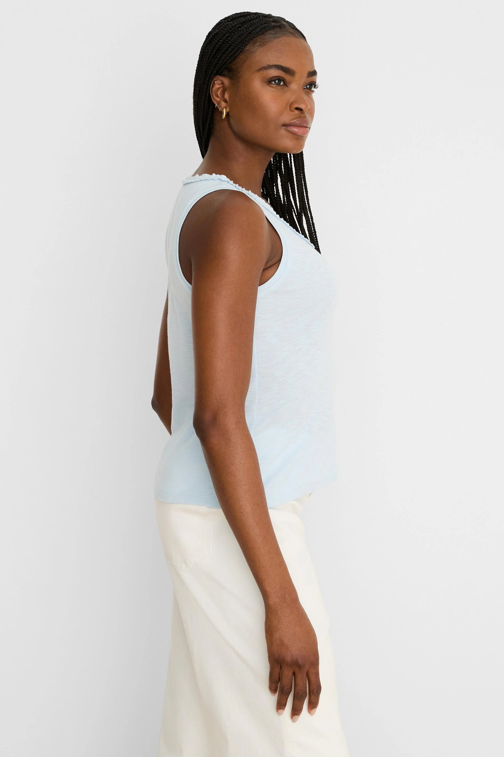 Light blue sleeveless tank with a ruffled neckline and slub cotton texture.