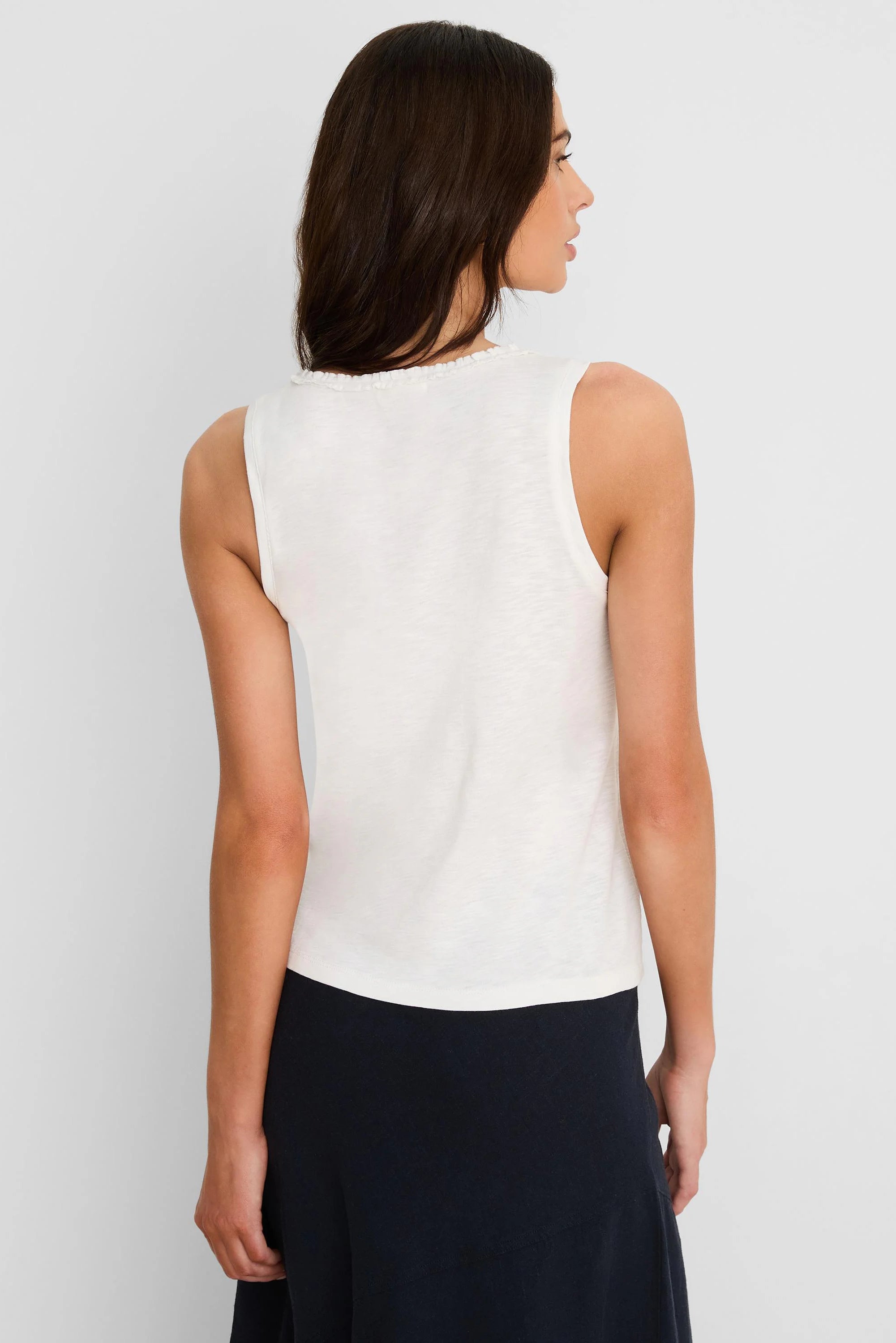 Off-white cotton slub tank top with a ruffle neck, seen from the back on a model.