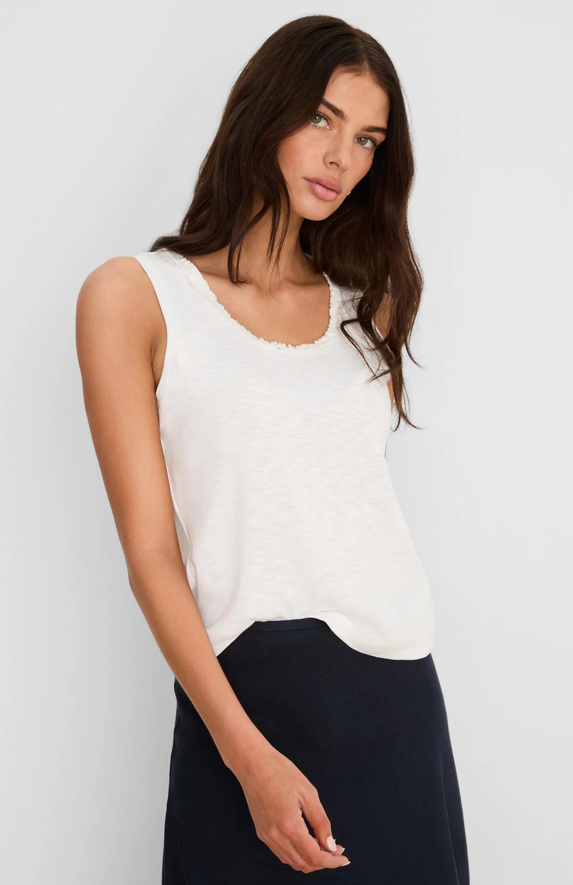 Cream cotton slub tank with a small ruffled neckline, worn by a model.
