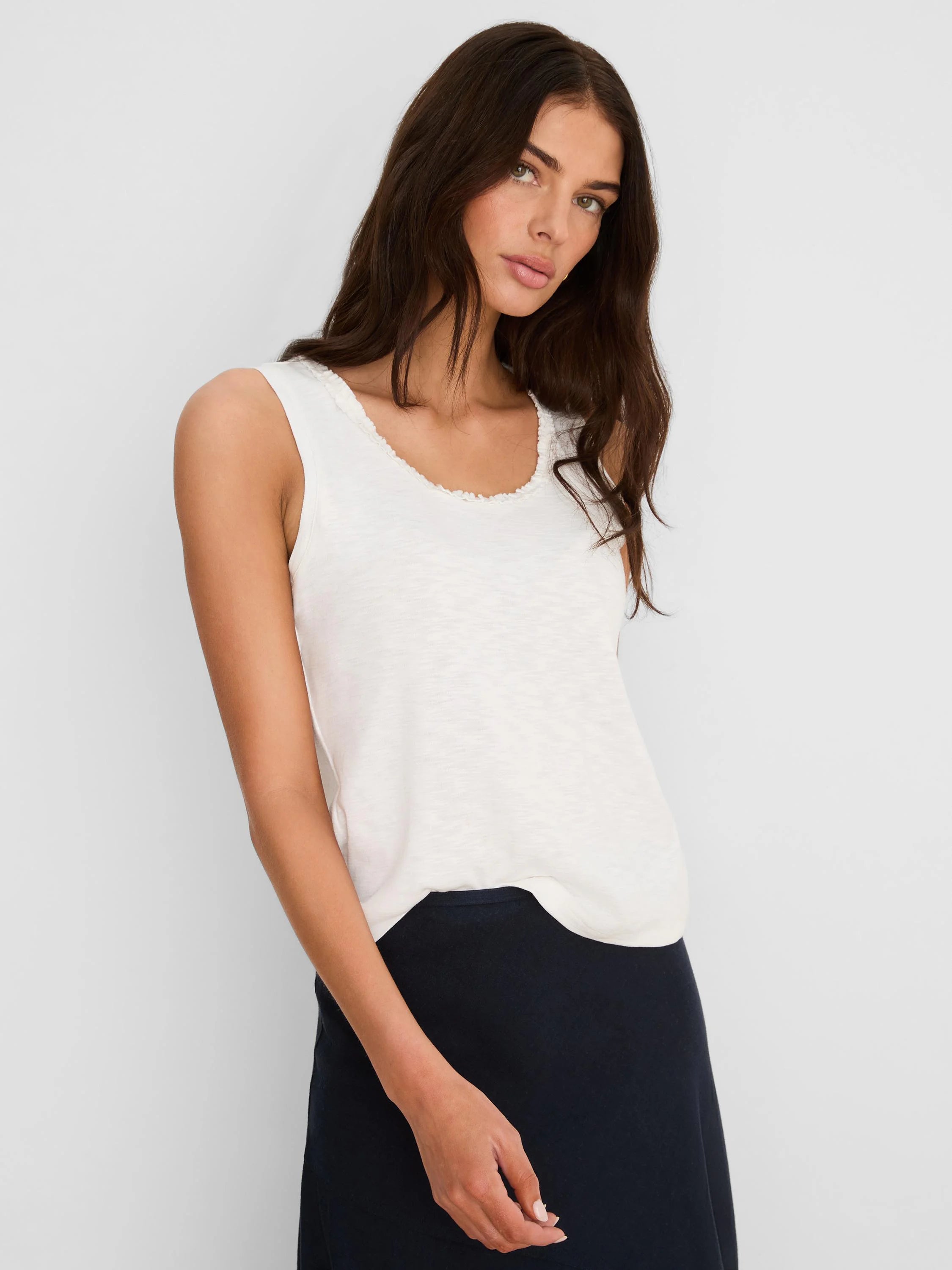 Cream cotton slub tank with a small ruffled neckline, worn by a model.