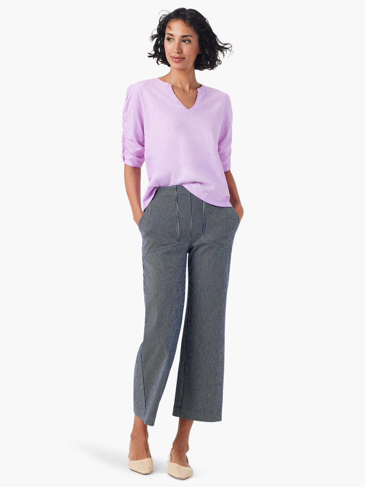 Lilac elbow-sleeve top with a split neck, shown on a model. The top is a textured fabric.