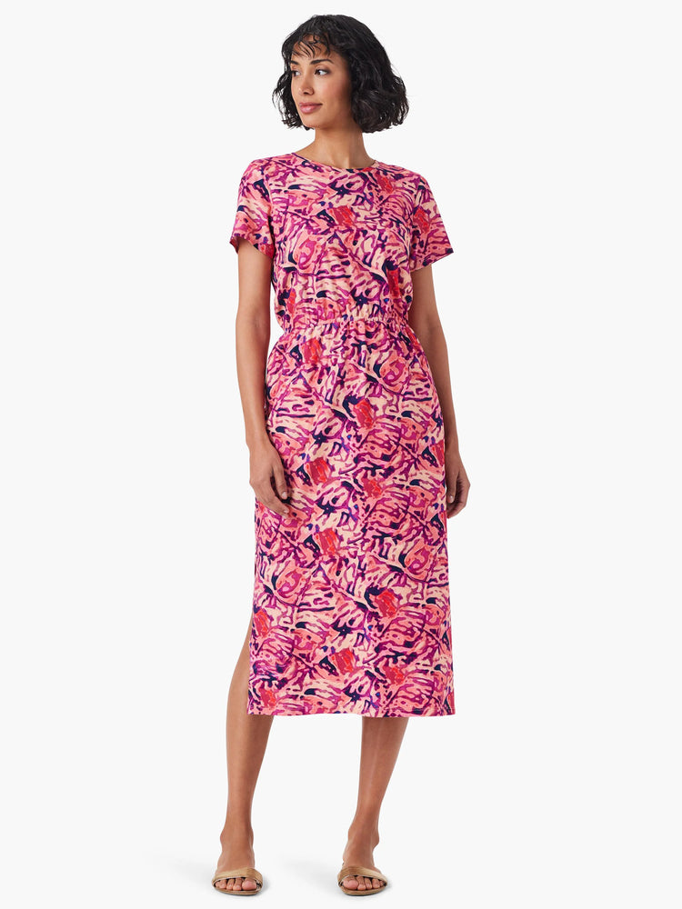 Pink midi dress with short sleeves, abstract pink, purple, and orange floral print, and side slit.
