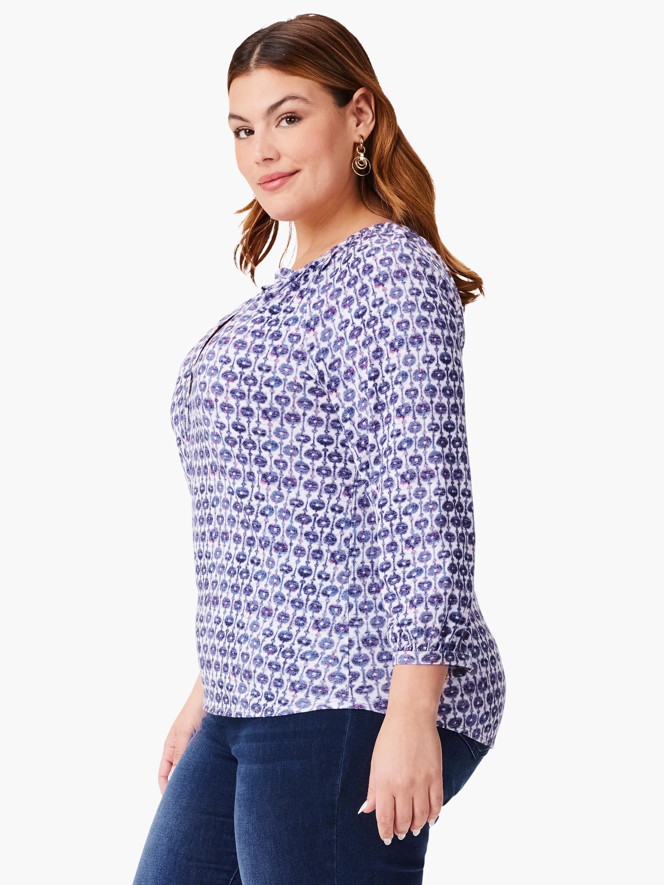 White top with a repeating purple and blue medallion pattern. Three-quarter sleeves.  Split neckline.