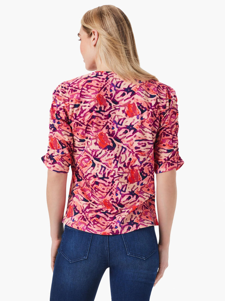Pink, red, and purple abstract floral print top. Ruched elbow-length sleeves. Split hem. Back view.