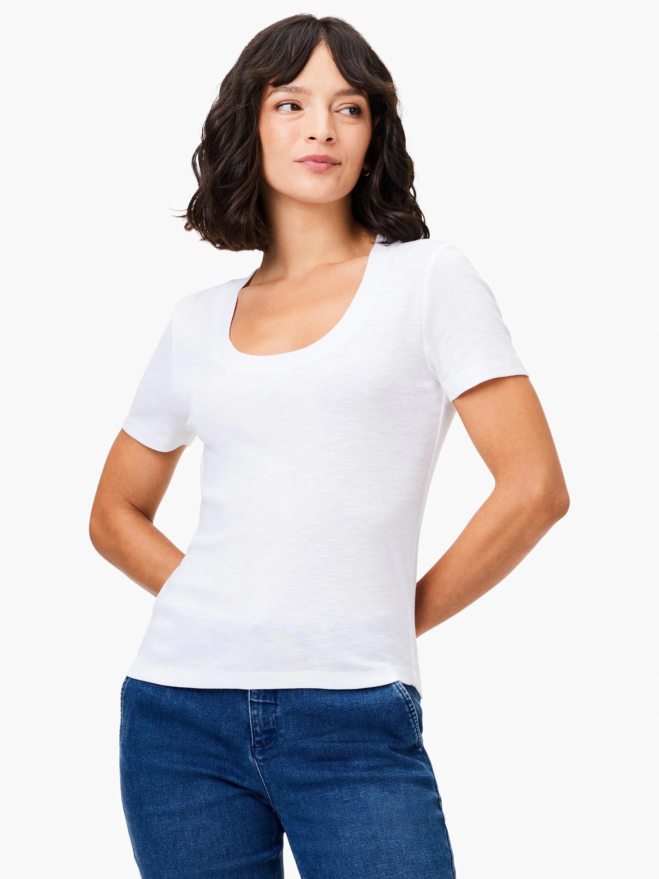 White scoop-neck short-sleeve tee. Slightly textured fabric. Model wears with dark wash jeans.