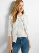 Off-white cardigan with thin gray stripes, long sleeves, and snap closures.
