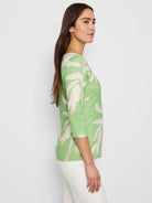 Light green 3/4 sleeve boat neck tee with off-white fern pattern.