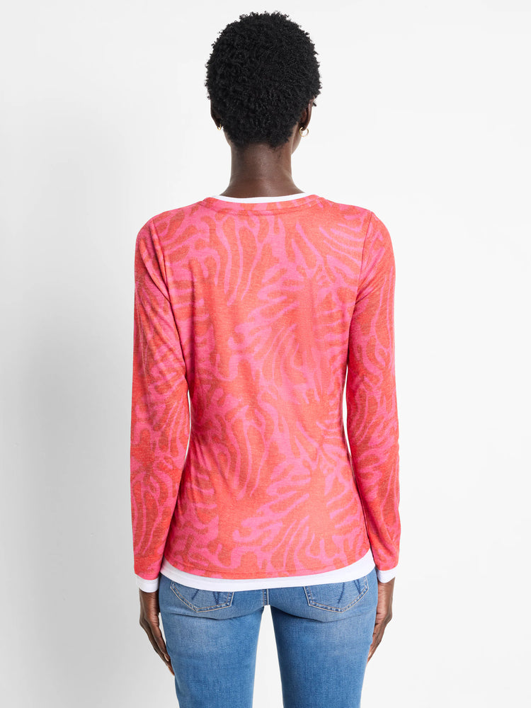 Pink long-sleeve top with darker pink leaf pattern. White detail at neckline.
