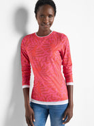 Pink long-sleeve top with a darker pink leaf pattern.  Double layered at the cuffs and hem; white inner layer shows.